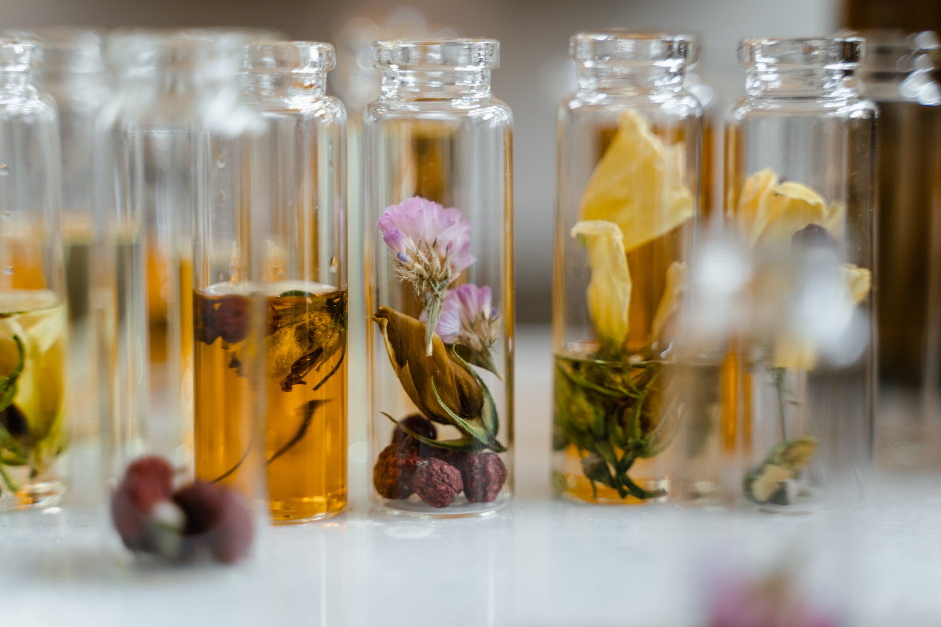 clear glass bottles with liquid and dry flowers